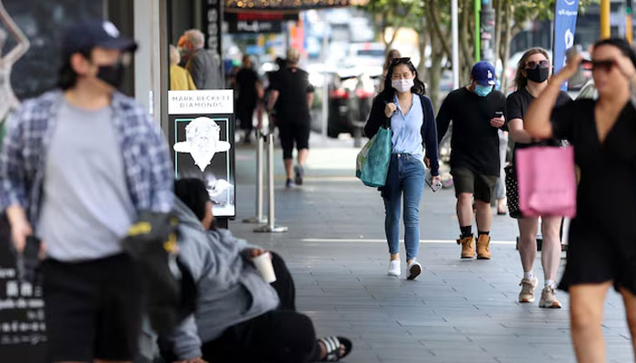 Shoppers walk through a retail district in Auckland, New Zealand on November 10, 2021. — Reuters