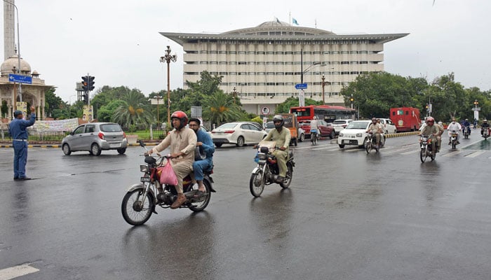 Motorists on their way at a road during rain in morning hours in Lahore on August 20, 2024. — Online