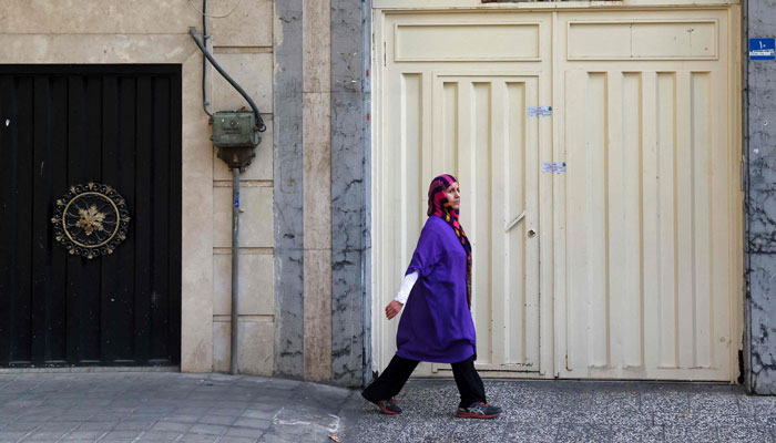 A woman walks past the closed gate of the Tehran offices of Germany´s Goethe-Institut cultural centre on August 20, 2024. — AFP