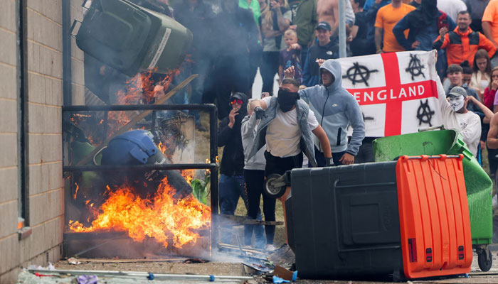 Protesters throw a garbage bin on fire outside a hotel in Rotherham, Britain, August 4, 2024. — Reuters