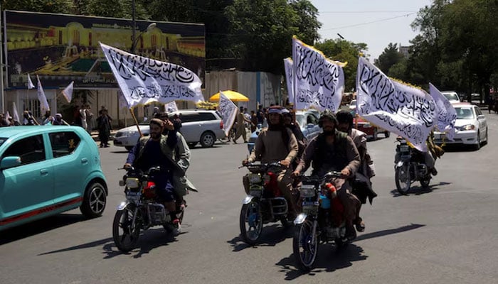 Members of the Taliban carrying flags ride motorbikes as they participate in a rally to mark the third anniversary of the fall of Kabul, in Kabul, Afghanistan on August 14, 2024. — Reuters