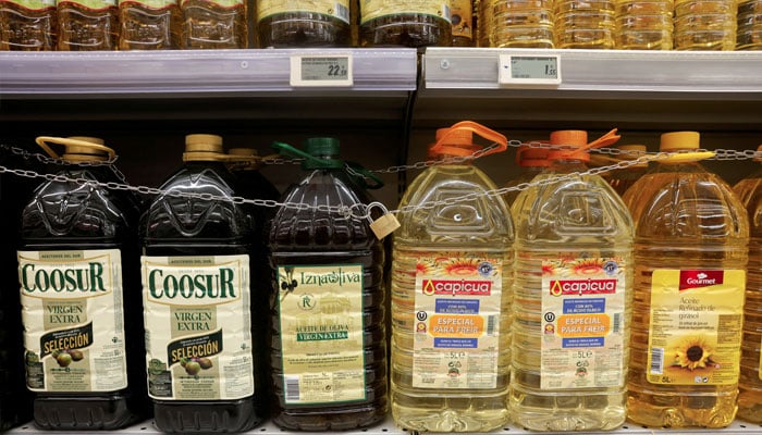 Olive and sunflower oil bottles are displayed for sale, protected by a padlock and a chain to prevent theft in a Tu Super Suma supermarket in Malaga, Spain, October 23, 2023. — Reuters