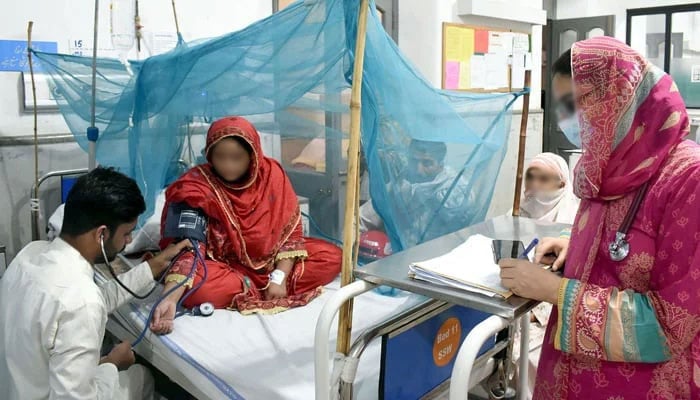 A doctor gives treatment to a dengue patient at a hospital in Lahore on October 8, 2023.— Online