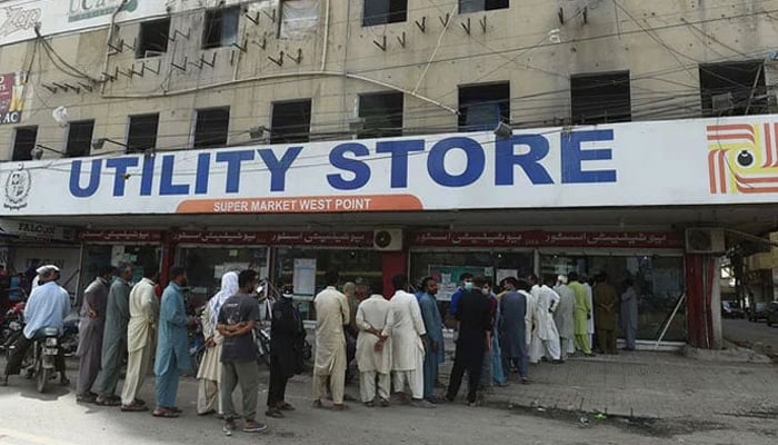 Peoples stand in a queue outside a state-run utility store to buy groceries. — AFP/File