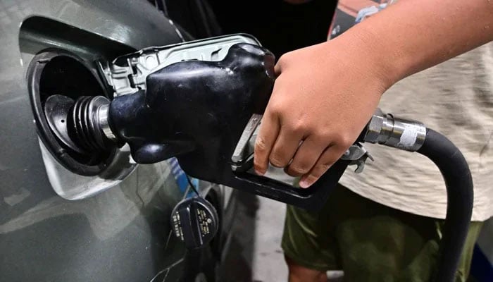 A man filling petrol in a vehicle at a petrol station on October 2, 2023. — AFP