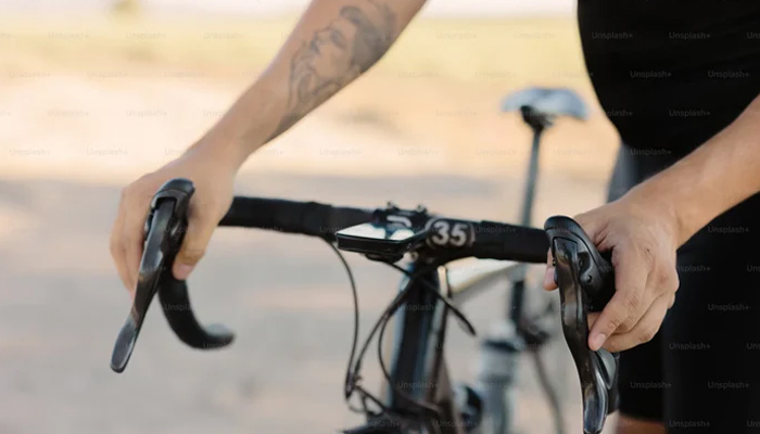 A representational image of a person holding a bicycle. — Unsplash/File