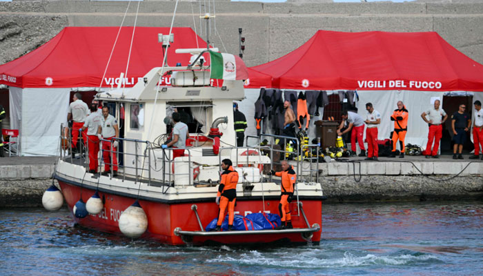 Divers of the Vigili del Fuoco, the Italian Corps. of Firefighters arrive in Porticello harbour near Palermo, with a third body at the back of the boat on August 21, 2024. — AFP