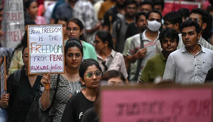 Medical professionals and students hold placards during a silent march as they condemn the rape and murder of a doctor, in Kolkata on August 15, 2024.— AFP