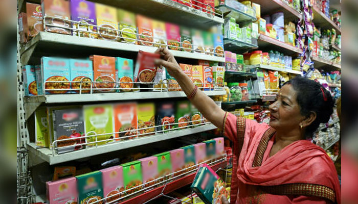 A woman buys spice packets in a store in Amritsar, India on May 21, 2024. — AFP