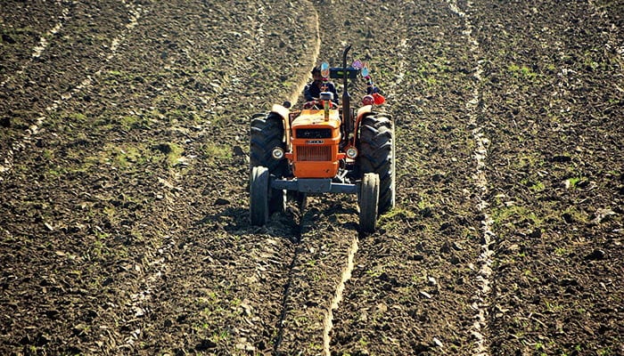 A farmer levels his farm field with the help of a tractor in Hyderabad on October 19, 2022. — APP