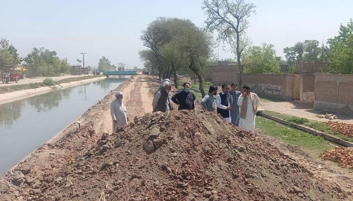 This representational image shows people standing near the Canal. — Facebook/Warsak Canals Division, Irrigation Department, KP/File