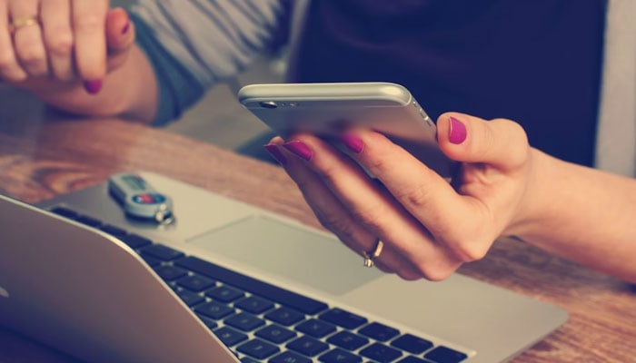 Representational image of a woman using their laptop and cell phone for e-commerce. — Unsplash/File