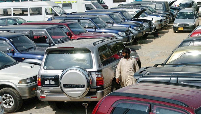 Representational image shows a Pakistani employee of a car showroom walking amidst new cars displayed at an auto dealer centre. — AFP/File