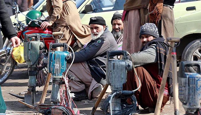 Representational image shows Labourers along with their tools sitting on the roadside waiting for clients to be hired for work at Khanna Pul. —  APP/File