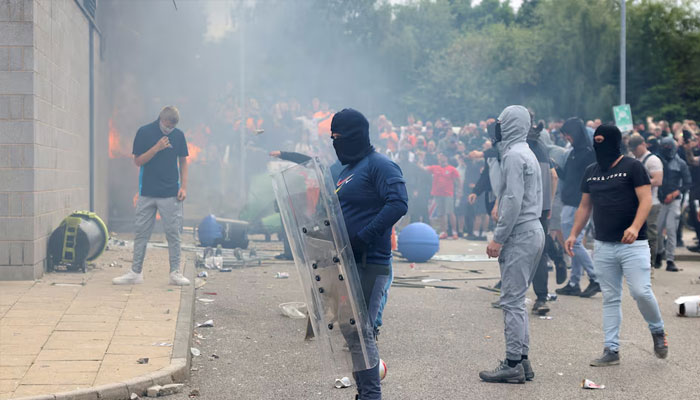 Protestors throw a garbage bin on fire outside a hotel in Rotherham, Britain, August 4, 2024. — Reuters