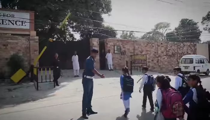 City Traffic Police Rawalpindi official is the children from the school van cross the road seen in this image on August 23, 2024. — Screengrab/Facebook/@ctprwp