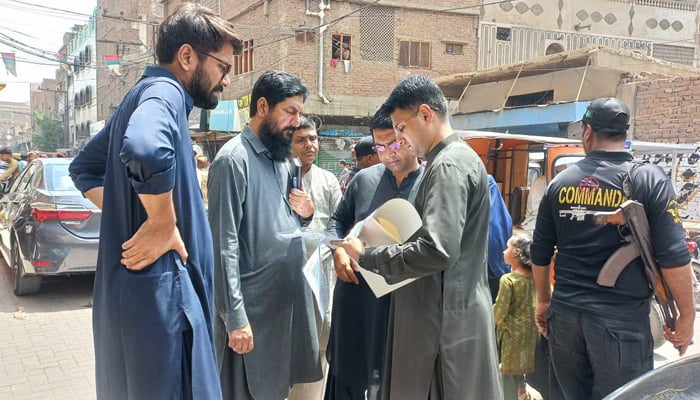 Hyderabad Deputy Commissioner Zain Ul Abideen Memon checking documents with some peoples in Hyderabad on August 23, 2024. — Facebook/@Deputy Commissioner Hyderabad