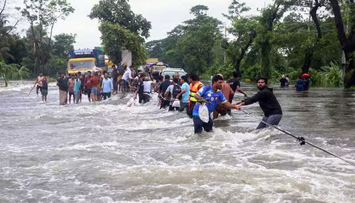 People wade through flood waters in Feni, Bangladesh on August 22, 2024. — AFP