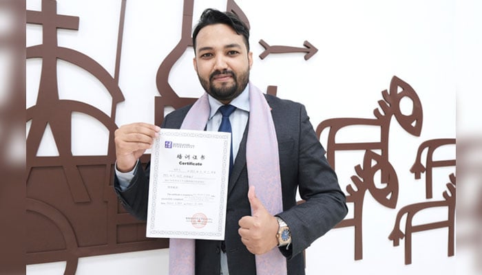 PU’s Chinese language teacher at Confucius Institute Abdullah Ze Hasham holds a certificate to pose for a photo on August 24, 2024. — PU website