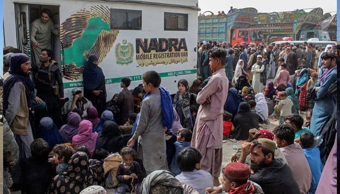 Afghan refugees gather in front of the National Database and Registration Authority (NADRA) vans for biometric verification before their departure to Afghanistan, at a holding centre near Pakistan-Afghanistan border in Chaman on November 1, 2023. — AFP