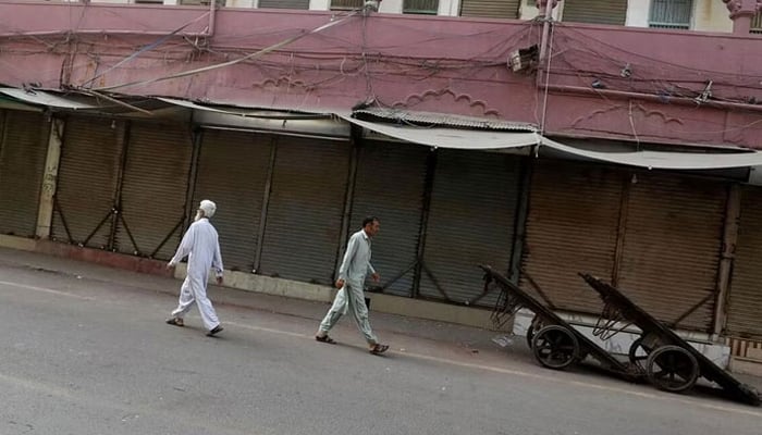 Men walk along a closed market, during a shutter down and wheel-jam strike in Malakand Division.  — Reuters/File