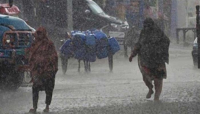 Women walk amid heavy rainfall in Sindh and Punjab. — AFP/File