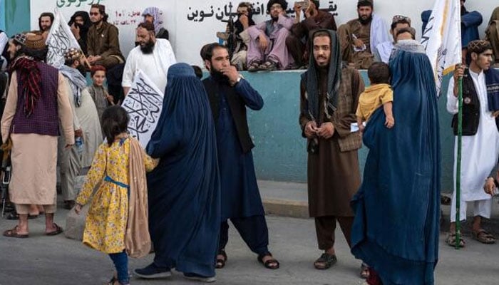 Burqa-clad women walk along a road during the celebration of third anniversary of Taliban takeover of Afghanistan near the Ahmad Shah Massoud square in Kabul on August 14, 2024. — AFP