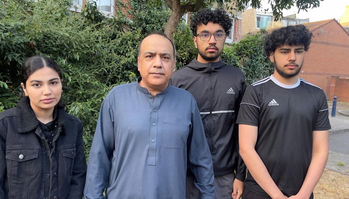 Mumtaz Khan (centre) poses for a photograph with his children in the UK. — Photo by reporter