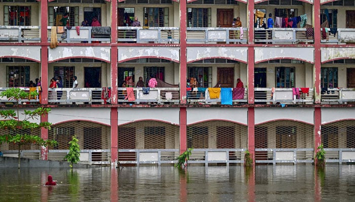 Flood-affected people take shelter inside a school building in Daganbhuiyan in Feni, Bangladesh on August 25, 2024. — AFP