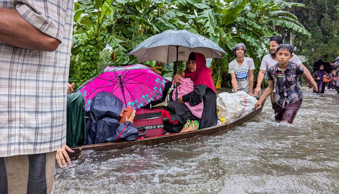 People wade through flood waters in Feni, Bangladesh on August 22, 2024. — AFP