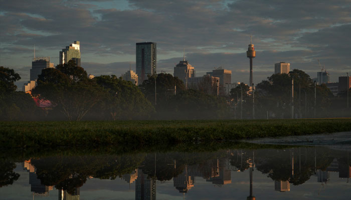 The city skyline is reflected in a puddle at sunrise following rainy weather in Sydney, Australia, August 28, 2022. — Reuters