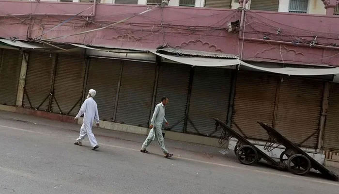 Men walk along a closed market, during a shutter down and wheel-jam strike in Malakand Division.  — Reuters/File