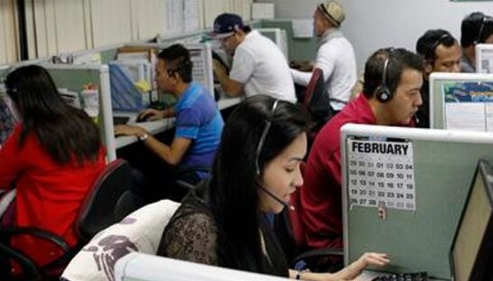 Call center agents work overnight daily to cater to United States clients in Manilas Makati financial district. — Reuters/File