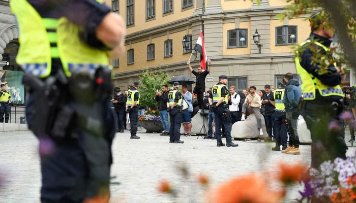 Policemen stand next to demonstrators at Mynttorget Square in Stockholm, Sweden, July 31, 2023. — AFP