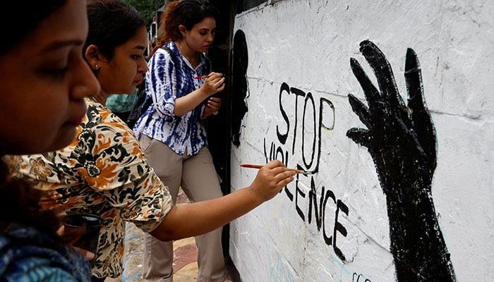 Medics paint slogans inside Kolkata Medical College and Hospital campus condemning the rape and murder of a female trainee medic at a government-run hospital, in Kolkata, India, August 19, 2024. — Reuters