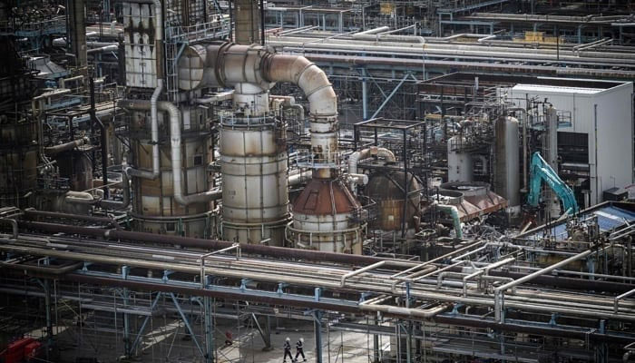 A representational image shows employees walking in the oil refinery, on September 8, 2023. — AFP