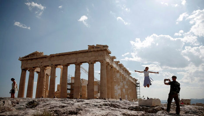 Tourists take a picture in front of the temple of the Parthenon atop the Acropolis in Athens, Greece July 20, 2018. — Reuters