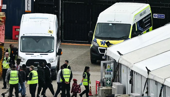 Migrants picked up at sea attempting to cross the English Channel from France are escorted ashore after disembarking at the marina in Dover, southeast England. — AFP/file