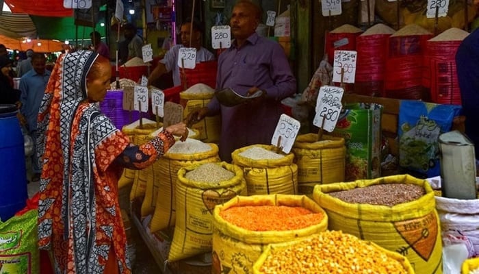 A customer buys rice at a shop in Karachi. — AFP/file