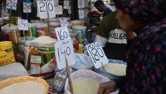 A woman checks rice prices at a main wholesale market. — AFP/File