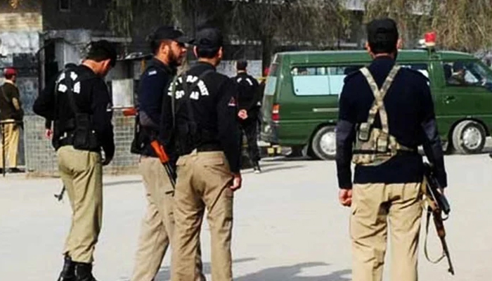 Police personnel can be seen standing on a road. — AFP/File