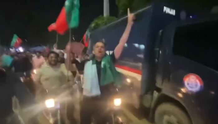 On Independence day member PTI is present with police van holding PTI flag on August 14, 2024. — Screengrab/Facebook/@PTIOIC