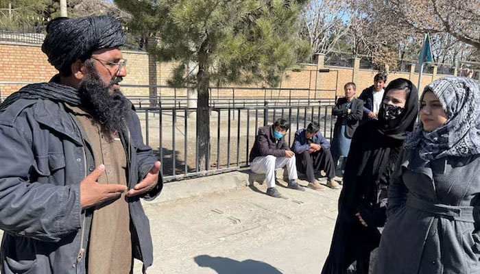 A member of Taliban speaks with female students outside the Kabul Education University in Kabul, Afghanistan, February 26, 2022. — Reuters