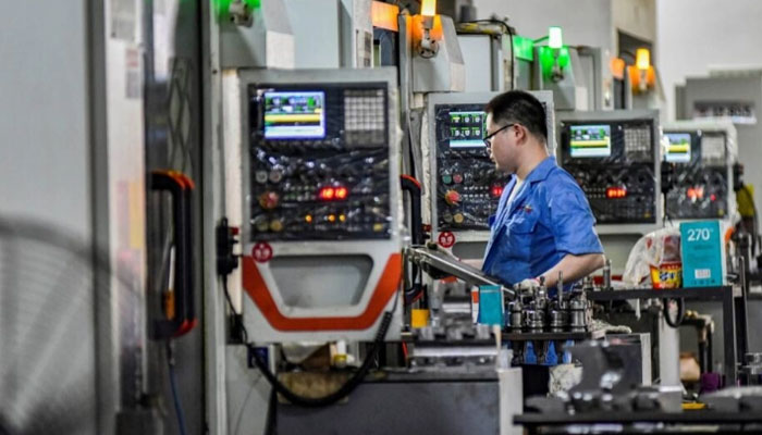 A worker on a production line at a printing and packaging factory in Qingzhou, eastern China. — AFP/File