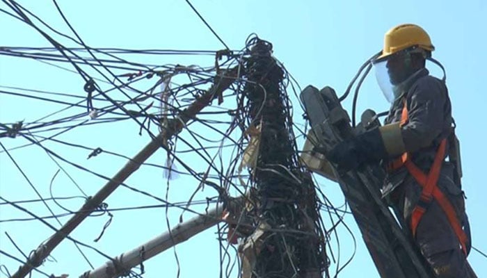 A representational image showing a KE personnel working on power lines. — KE website/File