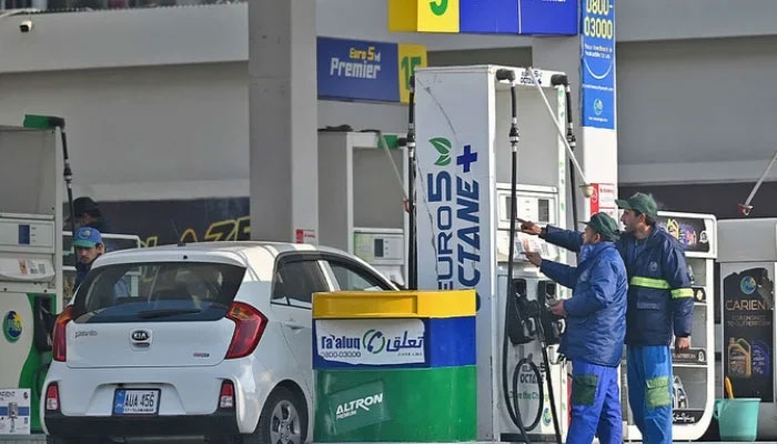 Employees at a fuel station attend to their customers in Islamabad, Pakistan, on February 16, 2022. — AFP/File