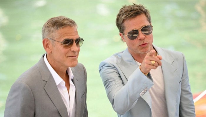 Actors Brad Pitt (R) and George Clooney arrive at the Casino pier during the 81st Venice International Film Festival at Venice Lido, on September 1, 2024 . — AFP