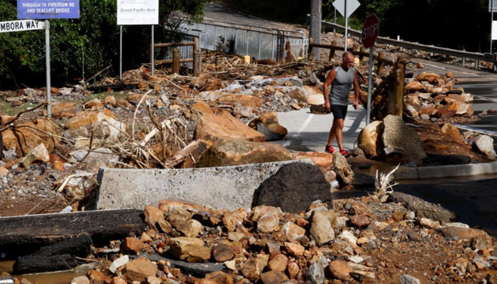 A resident walks past fallen rocks in Wollongong after heavy rain caused flooding in Australia. — AFP/File