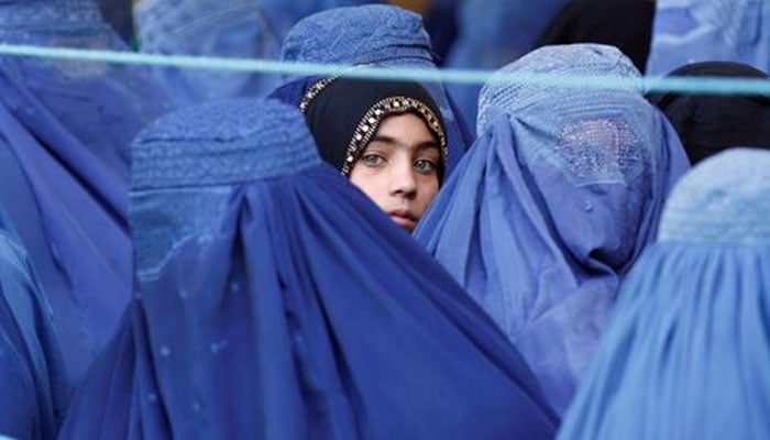 A girl looks on among Afghan women lining up to receive relief assistance in Jalalabad, Afghanistan. — Reuters/File