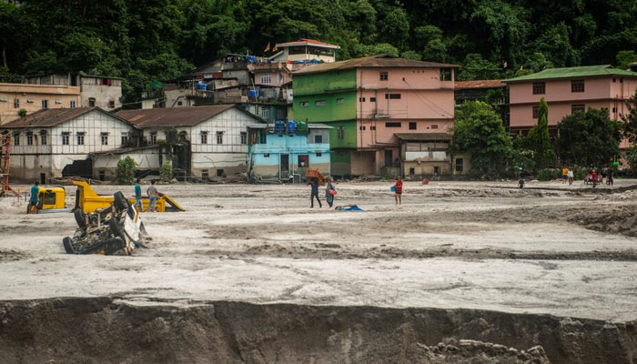 People walk along the area affected by the flood at Golitar, in Singtam, Sikkim, India on October 5, 2023. — Reuters